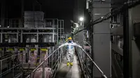 Kenichi Takahara, komunikator risiko dari perusahaan teknik dekontaminasi dan dekomisioning Fukushima Daiichi, mengunjungi sistem penghilangan multi-nuklida di Pembangkit Listrik Tenaga Nuklir (PLTN) Fukushima Daiichi milik Tokyo Electric Power Company (TEPCO) di Okuma, Prefektur Fukushima, Jepang, 20 Januari 2023. Situs ini menghasilkan 100.000 liter (3.500 kaki kubik) air yang terkontaminasi setiap hari. (Philip FONG/AFP)