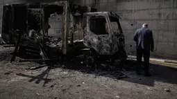 Penyerangan tersebut mengakibatkan cedera, penangkapan, serta kerusakan material yang luas. Tampak dalam foto, warga Palestina memeriksa kendaraan yang terbakar setelah serangan yang dilakukan oleh pemukim Israel pada hari sebelumnya di kawasan industri di desa Beit Lid, Tepi Barat, dekat Tulkarm, Rabu 12 November 2025. (AP Photo/Majdi Mohammed)