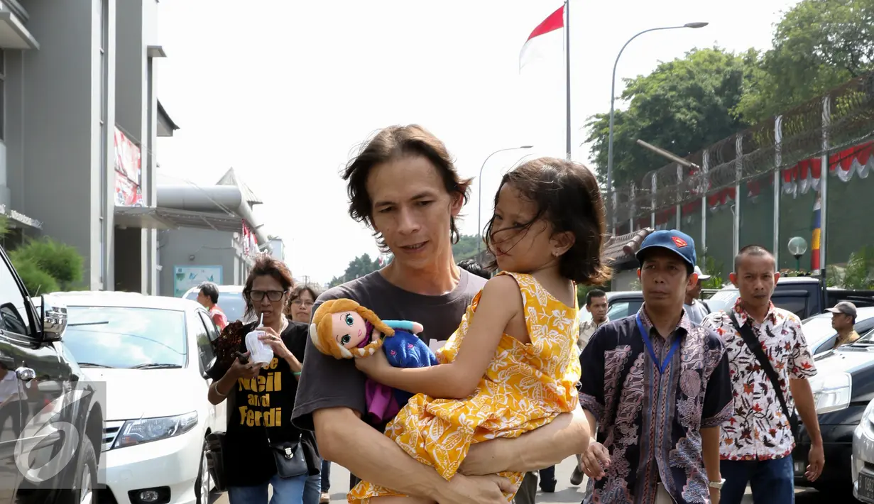 Ferdinant Tjiong memeluk anaknya usai keluar dari Rutan Cipinang, Jakarta, Jumat (14/8/2015).  Dua guru Jakarta International School (JIS) Neil Bantleman dan Ferdinant Tjiong diputuskan bebas oleh Pengadilan Tinggi Jakarta. (Liputan6.com/Yoppy Renato)