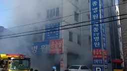 Kepulan asap terlihat saat petugas pemadam kebakaran berusaha memadamkan api yang membakar rumah sakit Sejong di Milyang, Korea Selatan,  Jumat (26/1). Bangunan lima lantai itu merupakan rumah sakit dan juga panti jompo. (Kim Dong-mi/Yonhap via AP)