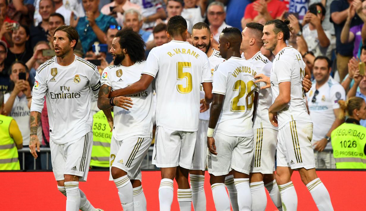 Para pemain Real Madrid merayakan gol yang dicetak Karim Benzema ke gawang Valladolid pada laga La Liga di Stadion Santiago Bernabeu, Madrid, Sabtu (24/8). Kedua klub bermain imbang 1-1. (AFP/Gabriel Bouys)