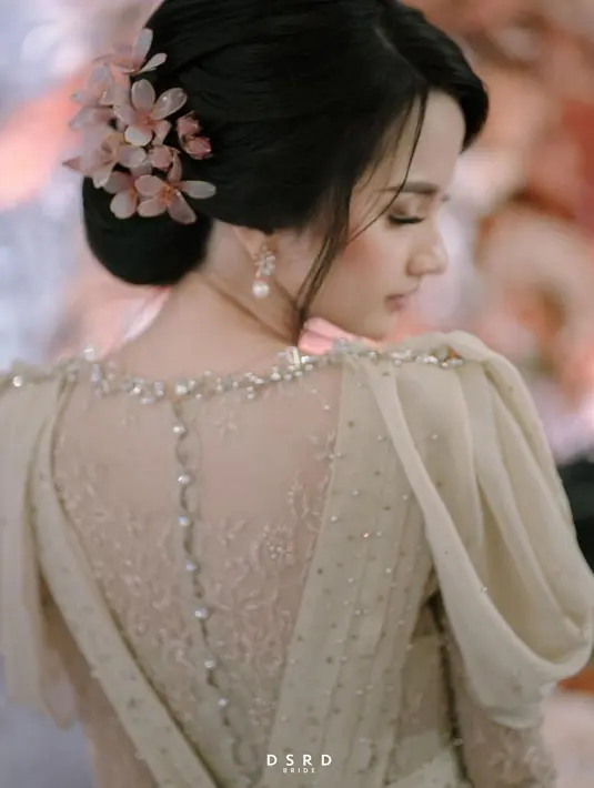 Tampilannya semakin cantik dengan gaya rambut updo, disertai sematan bunga yang semakin menambah kesempurnaan. (foto: dsrdbride)
