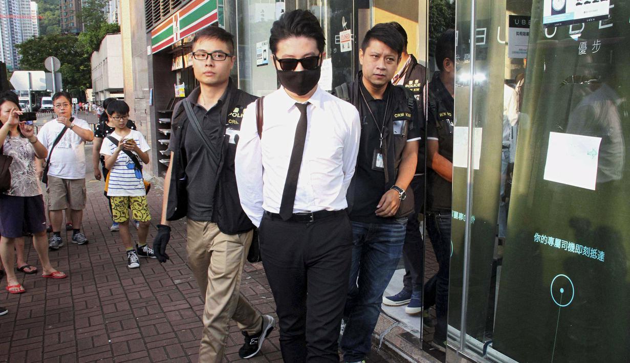 Polisi Hong Kong mengamankan seorang staff saat razia di kantor Uber Inc, Selasa (11/8/2015). Dalam razia ini polisi mengamankan 5 orang yang tertangkap basah memberikan jasa pelayanan sebagai sopir taxi dengan kendaraan ilegal. (REUTERS/Apple Daily)