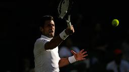 Petenis Serbia, Novak Djokovic mengembalikan bola ke petenis AS, Denis Kudla pada babak kedua Wimbledon di All England Lawn Tennis Club, London, Kamis (4/7/2019) dini hari. Djokovic melangkah ke babak ketiga setelah menang dengan skor 6-3 6-2 6-2. (AP Photo/Tim Ireland)