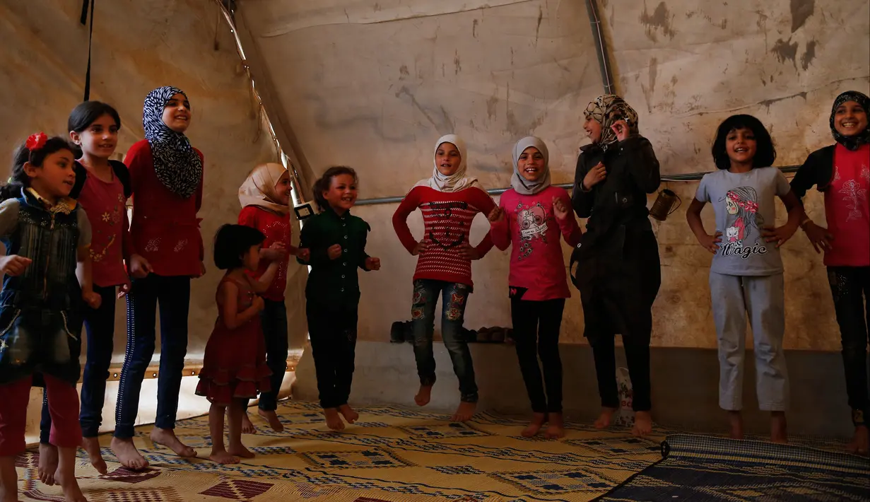 Anak-anak bernyanyi dalam kegiatan rekreasi di kamp pengungsian al-Bab, Suriah, Selasa (29/5). Jumlah penduduk al-Bab meningkat drastis akibat mendapat lonjakan pengungsi dari bagian lain Suriah. (AP Photo/Lefteris Pitarakis)