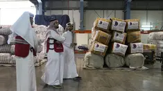 Karyawan Bulan Sabit Merah Qatar melewati pasokan paket bantuan yang akan dikirim untuk wilayah yang dilanda gempa di Turki, di Pangkalan Udara Al-Udeid di Qatar, Selasa, 7 Februari 2023. Gempa bumi dahsyat melanda Turki tenggara dan Suriah Senin dini hari, merobohkan ratusan bangunan serta menewaskan dan melukai ribuan orang. (AP Photo/Kamran Jebreili)