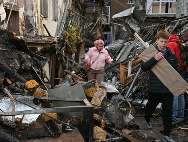 Warga setempat berjalan di halaman sebuah lingkungan perumahan yang rusak parah setelah serangan Rusia di Odesa, Ukraina, Jumat 24 April 2026. Gelombang serangan udara Rusia yang menggunakan kombinasi pesawat nirawak (drone) dan rudal kembali menghantam jantung permukiman warga Ukraina. (AP Photo/Michael Shtekel)