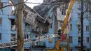 Tim penyelamat Ukraina di eskalator bekerja di bangunan tempat tinggal lima lantai yang hancur setelah serangan rudal di tengah invasi Rusia ke Ukraina di Zaporizhzhia pada 2 Maret 2023. Serangan Rusia di sebuah blok apartemen di kota Zaporizhzhia, Ukraina selatan telah menewaskan sedikitnya tiga orang, kata pihak berwenang setempat pada 2 Maret, saat operasi pencarian sedang berlangsung. (AFP/Katerina Klochko)
