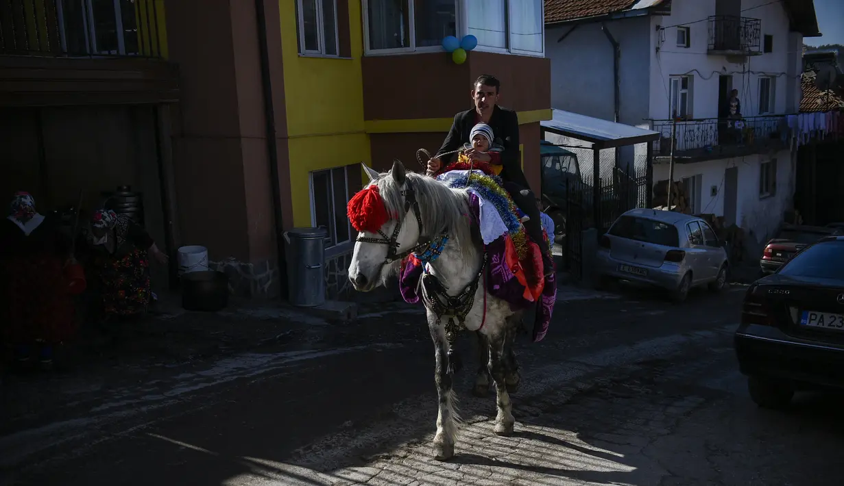 Seorang pria muslim Bulgaria menggendong putranya saat menunggang kuda selama upacara sunat massal untuk anak laki-laki di Desa Ribnovo, 11 April 2021. Penduduk Desa Ribnovo adalah muslim berbahasa Bulgaria, kadang-kadang disebut sebagai "Pomaks" atau "orang yang menderita". (Nikolay DOYCHINOV/AFP)