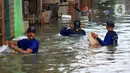 Petugas Sudin Sumber Daya Air (SDA) memunguti sampah-sampah yang tergenang saat banjir di kawasan Kampung Melayu Kecil, Bukit Duri, Jakarta, Selasa (25/2/2020). Banjir tersebut akibat luapan sungai Ciliwung. (merdeka.com/magang/ Muhammad Fayyadh)