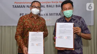 (ki-ka) Dirut PT Alita Praya Mitra Teguh Prasetya dan Kepala Balai Taman Nasional Bali Barat Dirjen KSDA dan Ekosistem Kementerian LHK,  Agus Ngurah Krisna menunjukkan naskah kerja sama pembangunan sarana komunikasi jaringan kabel serat optik di Bali, Kamis (27/10/2021). (Liputan6.com/HO/Alwi)