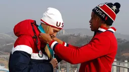 Atlet kereta luncur wanita AS Lauren Gibbs mengalungi medali perak kepada putri Presiden AS, Ivanka Trump selama kejuaraan Olimpiade Musim Dingin Pyeongchang 2018 di depan menara lompat ski di Pyeongchang (25/2). (AFP Photo/Pool/Eric Gaillard)