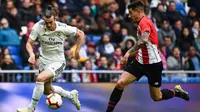 Aksi Gareth Bale melakukan manuver ke janung pertahanan Bilbao pada laga lanjutan La Liga di pekan ke-33 yang berlangsung di Stadion Santiago Bernabeu, Madrid, Minggu (21/4). Real Madrid menang 3-0 atas Bilbao. (AFP/Gabriel Bouys)