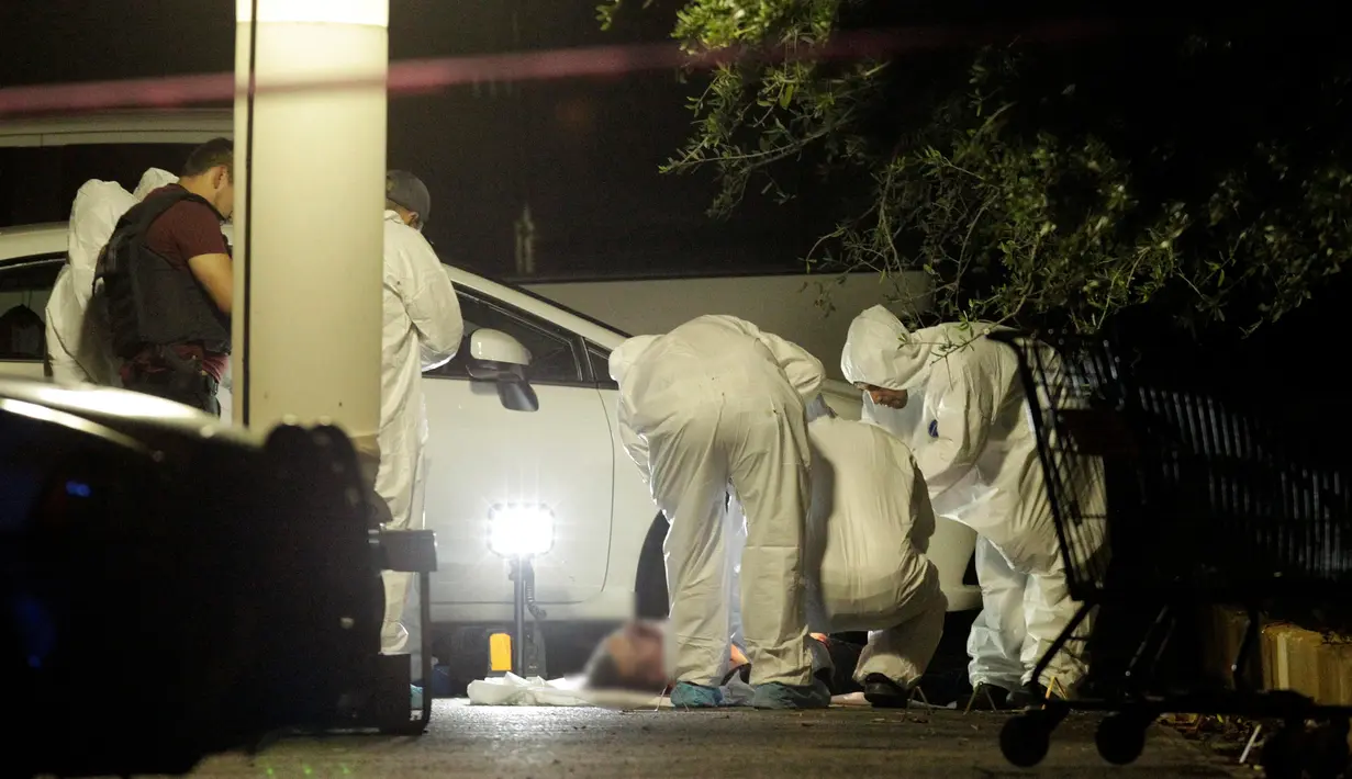  Tim forensik memeriksa tubuh seorang detektif polisi yang ditembak mati oleh penyerang tak dikenal di sebuah tempat parkir di San Pedro Garza, Monterrey, Meksiko, 9 Mei 2016. (REUTERS / Daniel Becerril)