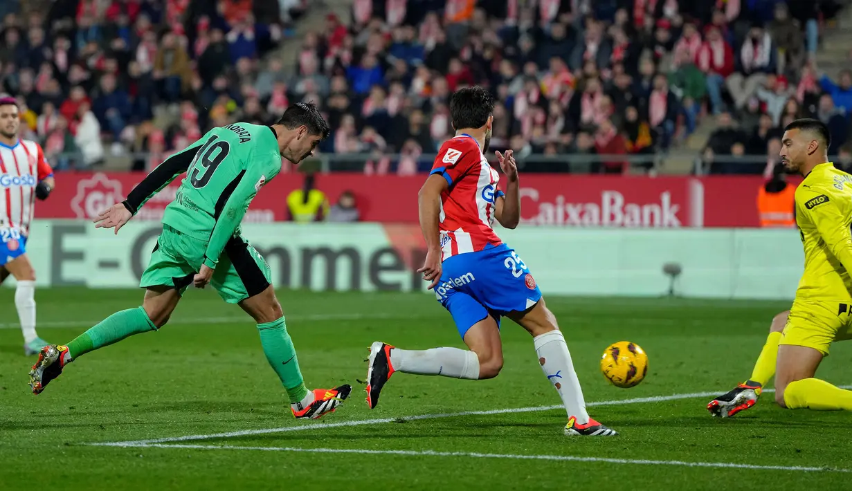Striker Atletico Madrid, Alvaro Morata (kiri) mencetak gol kedua timnya ke gawang Girona pada laga pekan ke-19 Liga Spanyol 2023/2024 di Montilivi Stadium, Girona, Kamis (4/1/2024) dini hari WIB. (AFP/Pau Barrena)