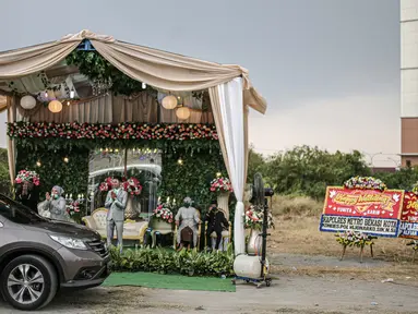 Suasana resepsi pernikahan secara "drive thru" di Bekasi, Jawa Barat, Sabtu (8/8/2020). Resepsi pernikahan secara drive thru menjadi alternatif pesta pernikahan guna mencegah penyebaran wabah COVID-19. (Liputan6.com/Faizal Fanani)