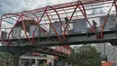 Pekerja menyelesaikan pembangunan jembatan penyeberangan orang (JPO) atau "Skywalk" di kawasan Kebayoran Lama, Jakarta, Sabtu (19/11/2022). Skywalk ini nantinya akan menghubungkan Stasiun Kebayoran Lama dengan halte Transjakarta Koridor 8 dan 13 dan akan rampung pada November 2022. (Liputan6.com/Angga Yuniar)