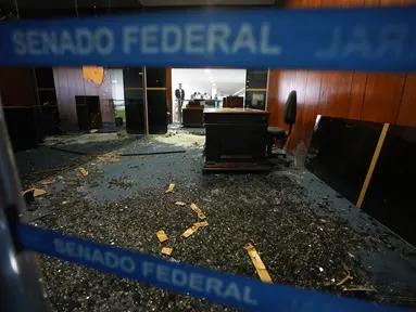 Pintu masuk kantor Presiden Senat hancur sehari setelah Gedung Kongres diserbu oleh pendukung mantan Presiden Brasil Jair Bolsonaro di Brasilia, Senin (9/1/2023). Para pengunjuk rasa juga menyerbu kantor kepresidenan, Istana Planalto, dan Mahkamah Agung. (AP Photo/Eraldo Peres)