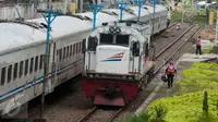 Petugas berjalan disamping kereta api di Stasiun Tanjung Priok, Jakarta Utara, Kamis (6/4). Acara HUT tersebut diselenggarakan oleh  PT Kereta Api Indonesia (KAI) Daop 1 bersama dengan Komunitas Pecinta Kereta Api Indonesia. (Liputan6.com/Gempur M. Surya)