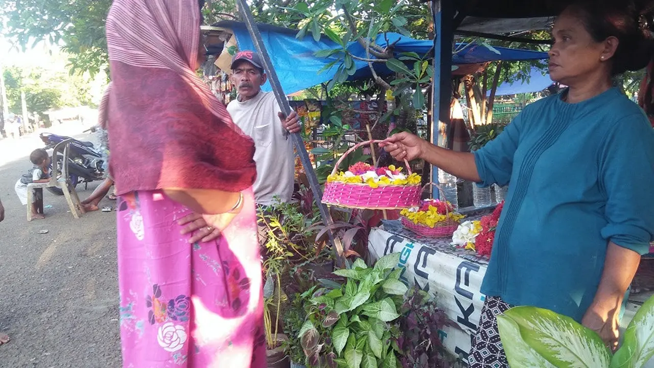 Nuraeni, pedagang bunga tertua di TPU Panaikang sedang tawarkan bunga ke peziarah (Liputan6.com/ Eka Hakim)