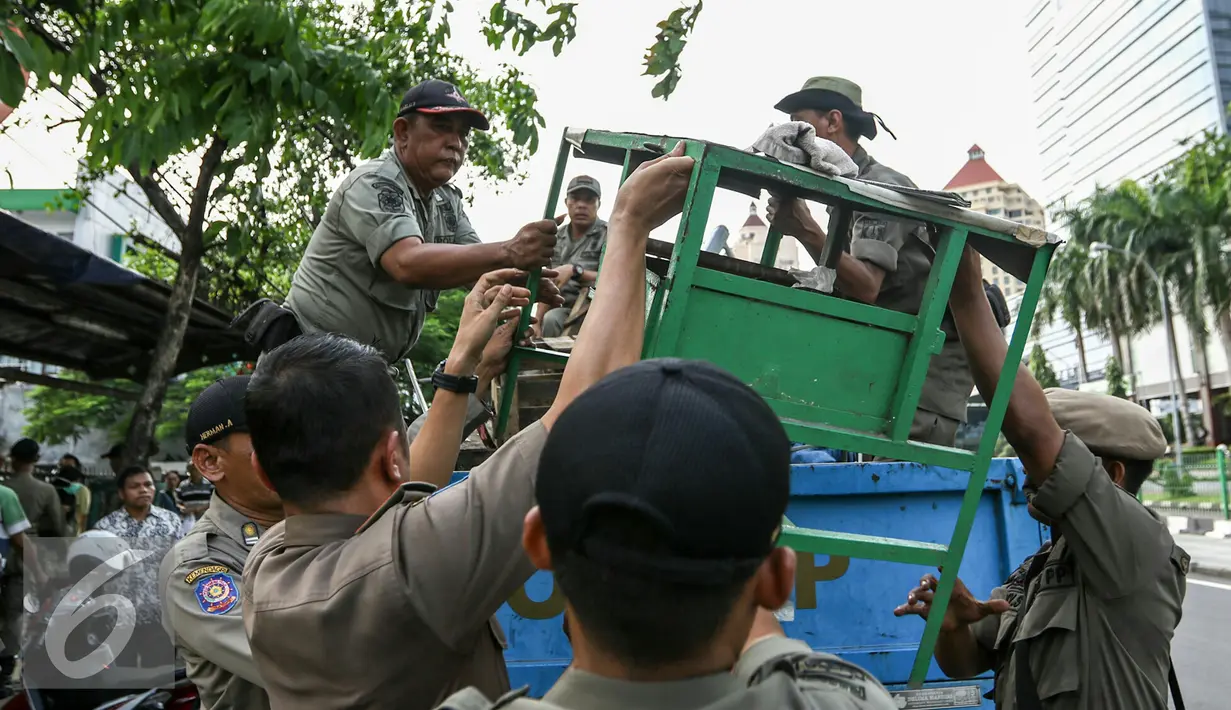 Petugas Satpol PP mengakut barang-barang PKL yang tetap nekat berjualan di trotoar, Jakarta, Selasa (29/3/2016). Puluhan Satpol PP gelar razia PKL yang nekat berjualan di trotoar di kawasan Senen, Jakarta Pusat. (Liputan6.com/Yoppy Renato)