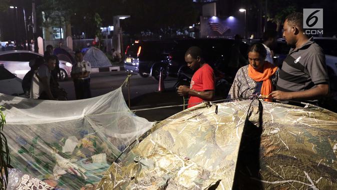 Pencari suaka mendirikan tenda untuk beristirahat di atas trotoar depan kantor UNHCR, Jalan Kebon Sirih, Jakarta, Jumat (5/7/2019). Para pencari suaka ini membangun tenda-tenda dan meminta kepastian perlindungan dari UNHCR . (Liputan6.com/Helmi Fithriansyah)