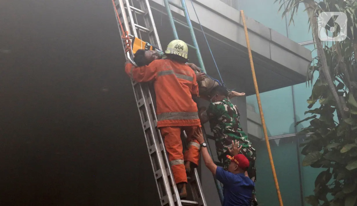 Petugas pemadam kebakaran mengevakuasi korban kebakaran di Gedung Cyber 1, Jakarta, Kamis (2/12/2021). Saat ini, ketiga korban telah dibawa ke RSUD Mampang. (Liputan6.com/Herman Zakharia)