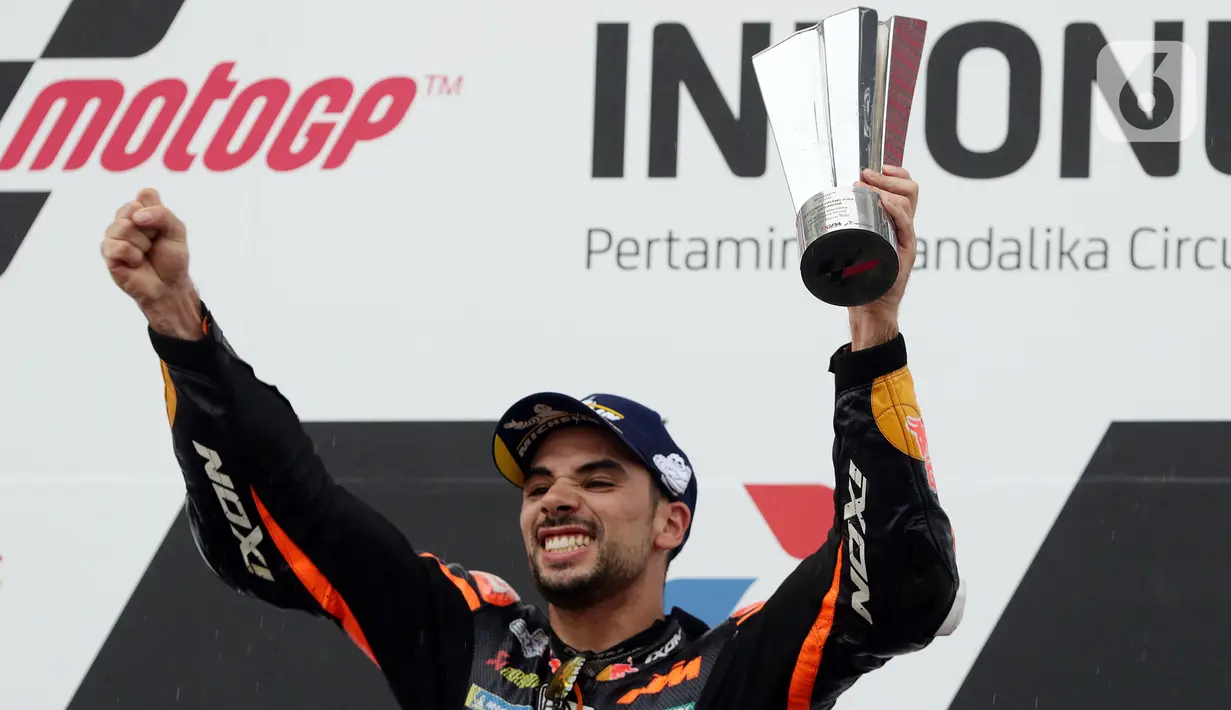 Pembalap MotoGP dari tim Red Bull KTM Factory Racing, Miguel Oliveira mengangkat piala usai memenangi ajang Pertamina Mandalika International Street Sirkuit, Nusa Tenggara Barat, Minggu (20/3/2022). Miguel Oliveira menempati podium utama ajang MotoGP Mandalika. (Liputan6.com/Helmi Fithriansyah)
