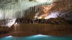 Pengunjung berada di dalam gua alam Choranche, di wilayah Vercors dekat Grenoble, Prancis (3/8). Sejak dimulainya gelombang panas, telah terjadi peningkatan setidaknya 10 persen jumlah pengunjung gua. (AFP Photo/Jean-Pierre Clatot)