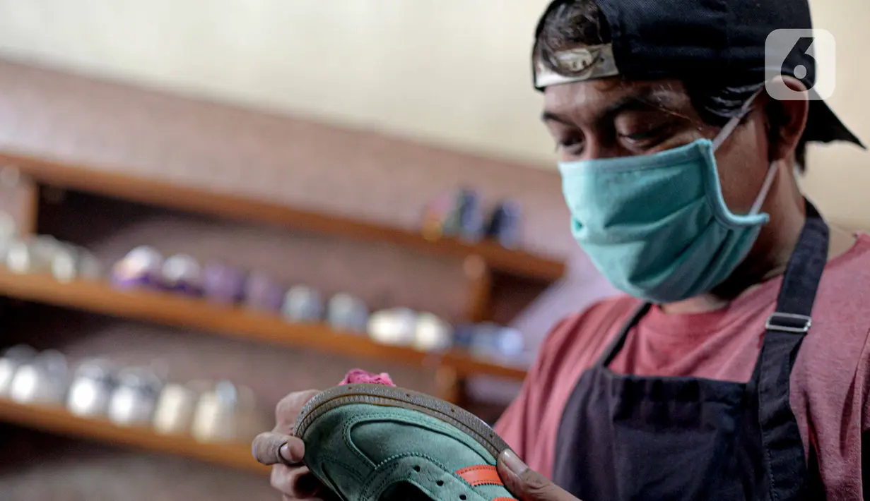 Kru membersihkan sepatu pelanggan di Soul Sepatu di kawasan Rawamangun, Jakarta, Senin (9/11/2020). Dalam sehari, mereka mampu menyelesaikan 20 pasang sepatu, yang dimulai dari harga Rp35 ribu hingga Rp75 ribu. (Liputan6.com/Faizal Fanani)