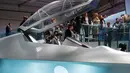 Pengunjung berada di jet tempur baru 'Tempest' milik Inggris selama Farnborough Airshow di London, Inggris (16/7). Jet tempur Tempest akan mulai digunakan militer Inggris tahun 2035 mendatang karena masih dalam pengembangan. (AFP Photo/Tolga Akmen)