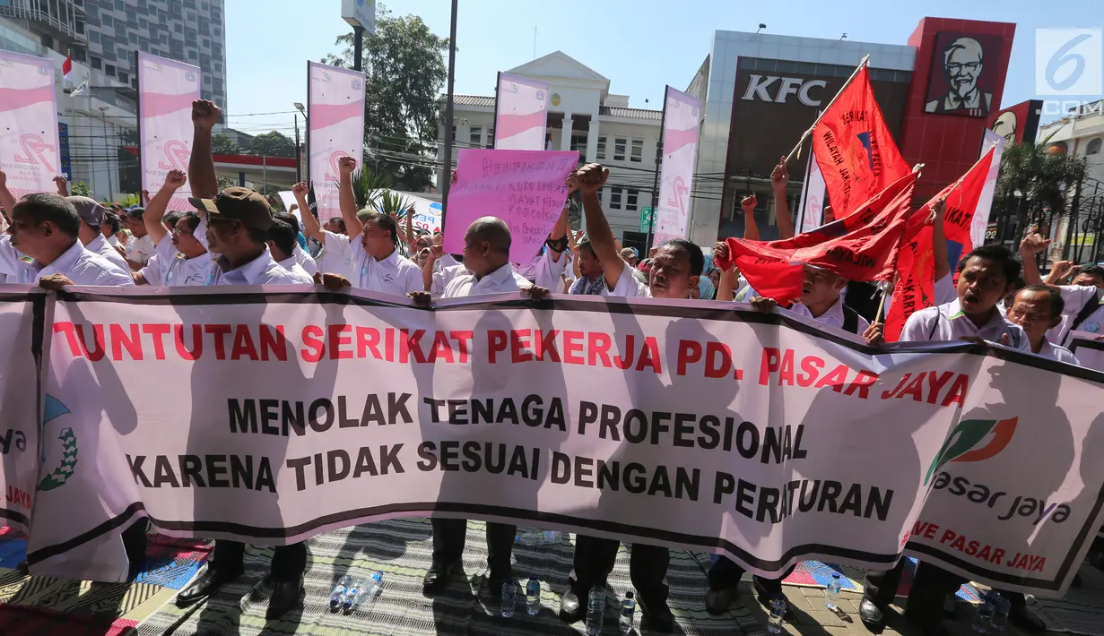 Serikat Pekerja (SP) PD Pasar Jaya membentangkan spanduk dalam unjuk rasa di depan Kantor PD Pasar Jaya, Jakarta, Rabu (2/8). Selain keberatan dengan pengangkatan tenaga profesional, mereka juga menyoroti kesenjangan pendapatan (Liputan6.com/Angga Yuniar)