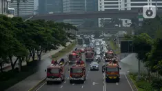 Petugas pemadam kebakaran (Damkar) dengan mobil pemadam melakukan penyemprotan cairan disinfektan di sepanjang jalan Thamrin-Sudirman, Jakarta, Sabtu (28/3/2020). Penyemprotan dilakukan untuk meminimalisir penyebaran COVID-19 di ruang udara dan ruas jalan. (merdeka.com/Imam Buhori)