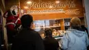 Pelanggan mengantre untuk membeli Bolo Rei atau Kue Raja di toko roti Padaria da Ne, Amadora, Portugal, 16 Desember 2022. Saat merayakan Natal, orang Portugal hampir tidak pernah melewatkan Bolo Rei dari sajian mereka. (CARLOS COSTA/AFP)