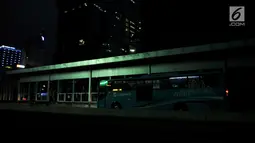 Bus Transjakarta berhenti untuk mengangkut penumpang saat listrik padam di Halte Tosari, Jakarta, Minggu (4/8/2019). Pemadaman listrik serentak yang terjadi sejak Minggu siang mengubah suasana malam di ibu kota menjadi gelap gulita. (merdeka.com/Iqbal S. Nugroho)
