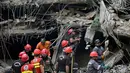 Otoritas kesehatan setempat terus memperbarui data jumlah korban luka maupun korban jiwa seiring dengan berlanjutnya proses evakuasi di lapangan. Tampak dalam foto, petugas penyelamat mencari di tengah reruntuhan setelah kebakaran besar di sebuah pusat perbelanjaan di Karachi pada Senin 19 Januari 2026. (Asif HASSAN/AFP)