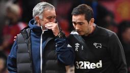 Pelatih Derby County, Frank Lampard, berbincang dengan pelatih Manchester United, Jose Mourinho, pada Piala Liga Inggris di Stadion Old Trafford, Rabu (26/9/2018). Manchester United takluk adu penalti 9-10 (2-2) dari Derby County. (AFP/Paul Ellis)