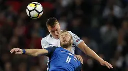 Duel pemain Inggris, Phil Jones (atas) dan pemain Slovakia, Adam Nemec pada laga grup F kualifikasi Piala Dunia 2018 di Wembley stadium, London, (4/9/2017). Inggris menang 2-1. (AP/Kirsty Wigglesworth)