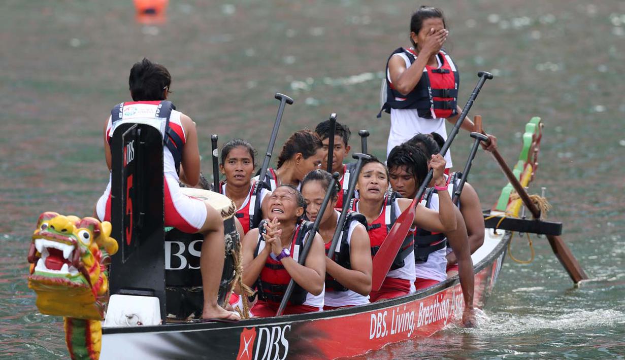 Tim putri Indonesia meluapkan kegembiraan setelah meraih medali emas saat berlomba di nomor 12 Kru 200m Perahu Naga SEA Games 2015 di Marina Bay, Singapura. Sabtu (6/6). (Bola.com/Arief Bagus)