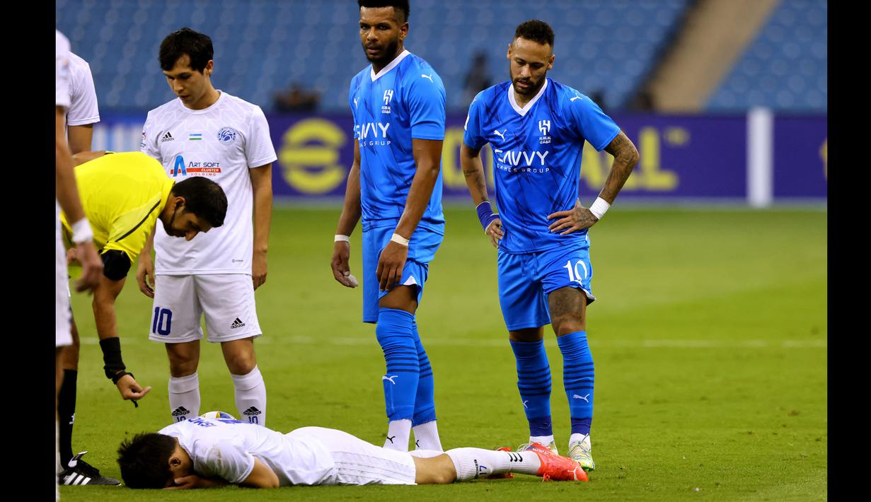 Bek PFC Navbahor, Abror Ismailov (bawah) terbaring di lapangan usai insiden dengan striker Al Hilal, Neymar (kanan) pada laga Grup D Liga Champions Asia 2023/2024 di King Fahd International Stadium, Riyadh, Selasa (19/9/2023) dini hari WIB. (AFP/Fayez Nureldine)