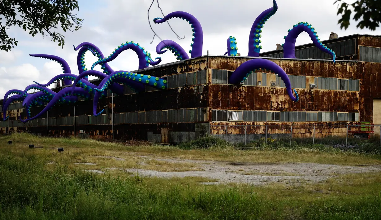 Sebuah patung karet berjudul "Sea Monsters HERE" menghiasi gudang berkarat Building 61 di Navy Yard di Philadelphia, Selasa (9/10). Instalasi buatan seniman Inggris Filthy Luker dan Pedro Estrellas ini ditampilkan hingga 16 November 2018. (AP/Matt Rourke)