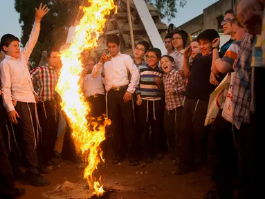 Pemuda Yahudi Ultra Ortodoks bermain api selama liburan Yahudi Lag Ba'Omer di Bnei Brak, Israel (2/5). Perayaan Lag Ba'Omer ini menandai berakhirnya musim wabah menurut kepercayaan mereka. (AP Photo / Oded Balilty)