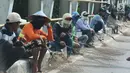 Sejumlah penyapu koin duduk sambil menunggu koin yang dilempar ke jalan di kawasana Subang, Jawa Barat, Sabtu (7/1). Pasca Lebaran warga yang menjadi penyapu uang koin menjadi banyak dibanding hari biasanya. (Liputan6.com/Helmi Afandi)