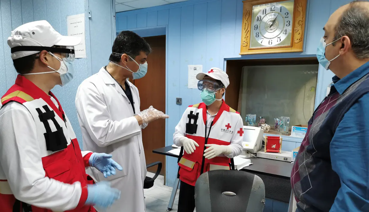 Anggota tim pakar medis China, Chen Huai (kedua kanan) dan Ai Hexu (kiri) berbicara dengan dua ahli radiologi lokal di Baghdad, Irak, Senin (30/3/2020). Sejak 7 Maret lalu, tujuh pakar medis China bekerja sama dengan tenaga ahli lokal di Irak untuk memerangi epidemi virus corona COVID-19. (Xinhua)
