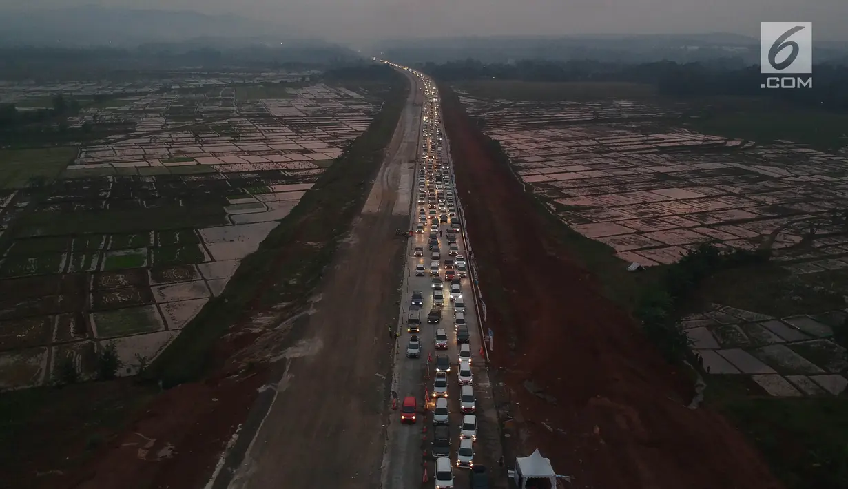 Foto udara kepadatan pemudik untuk keluar dari ruas Tol Batang-Semarang menuju jalur Pantura Batang-Kendal di Kali Kuto, Gringsing, Kabupaten Batang, Jawa Tengah, Senin (11/6). (Liputan6.com/Arya Manggala)