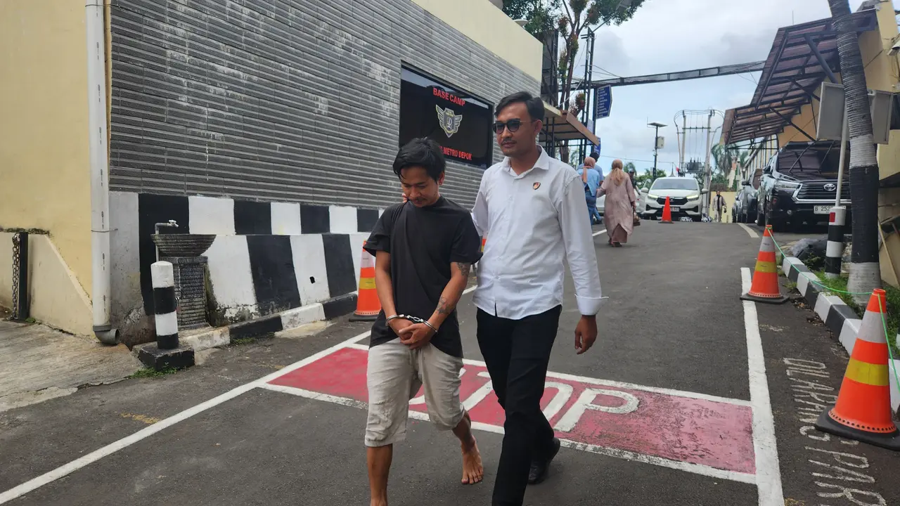 Tersangka KDRT terhadap istrinya saat di bawa ke Polres Metro Depok.