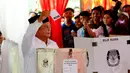 Sesudah menggunakan hak suaranya, ia memperlihatkan kertas suara yang baru saja ia pilih. (Liputan6.com / Andrian Martinus)