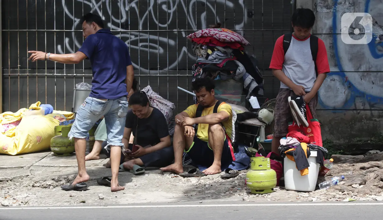 Warga mengamankan barang berharga saat api membakar pemukiman di kawasan Jalan Kebayoran Lama, Jakarta, Minggu (30/10/2022). Sebanyak 20 unit mobil damkar dikerahkan. Total sekitar 100 personel yang turun ke lokasi memadamkan api. (Liputan6.com/Helmi Fithriansyah)