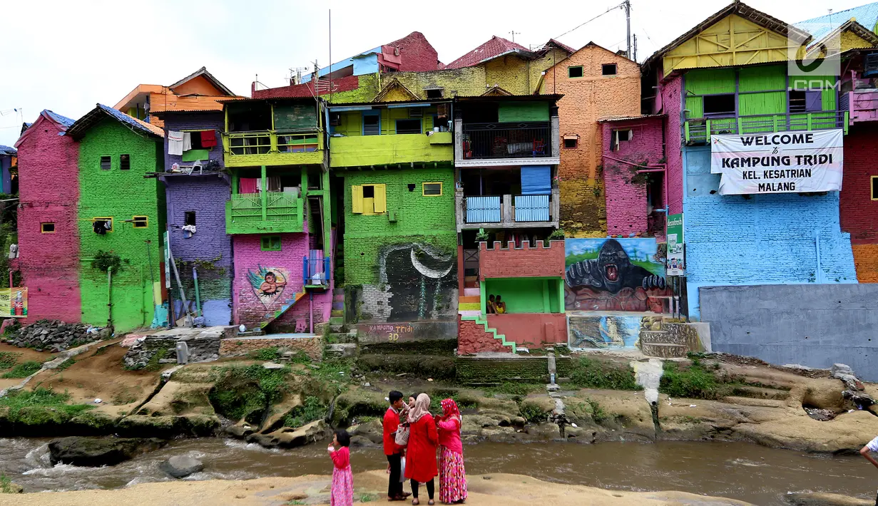 Suasana kampung warna-warni di Kelurahan Kesatrian, Kota Malang, Minggu (5/11). Ratusan rumah yang berdiri di bantaran Sungai Brantas di cat gambar warna-warni. (Liputan6.com/Fery Pradolo)