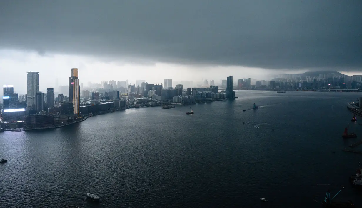 Pemandangan menunjukkan badai awan menjulang di atas cakrawala Kowloon dan Pelabuhan Victoria sebelum hujan lebat di Hong Kong (6/3). (AFP Photo/Anthony Wallace)
